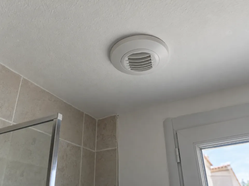 Bouche d'extraction de VMC au plafond d'une salle de bain